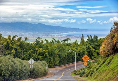 Central Maui road overlooking the town and coast below, framed by mountains